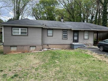 Charming single-story home featuring a neutral color palette, a carport, and a cozy front lawn at 4632 Burks Rd, Forest Park, GA 30297