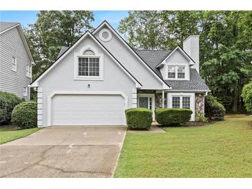 Charming home featuring stone accents, a two-car garage, and a well-maintained lawn at 995 Litchfield Pl, Roswell, GA 30076