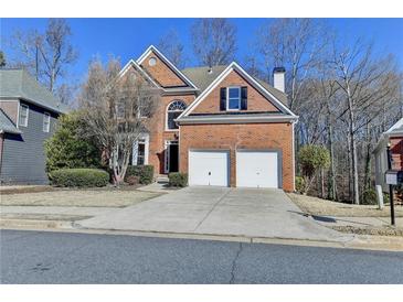 Charming two-story brick home with a well-manicured lawn, two-car garage, and a welcoming front entrance at 1924 Wilkenson Xing, Marietta, GA 30066