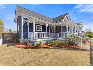 Charming two-story home featuring a welcoming front porch with white railings and a well-maintained lawn at 459 James P Brawley Nw Dr, Atlanta, GA 30318