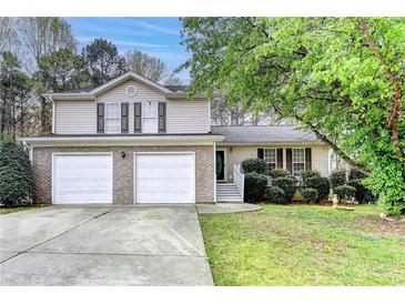 Charming two-story home with a two-car garage and a well-manicured front yard at 5880 April Dr, Sugar Hill, GA 30518