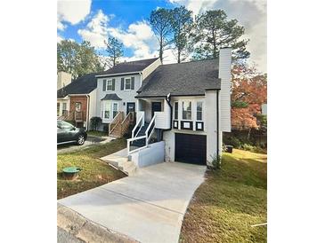 Inviting two-story home with a well-maintained lawn and a paved driveway leading to an attached garage at 1118 Magnolia Se Way, Smyrna, GA 30082