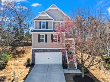 Charming two-story home with stone accents, a two-car garage, and a well-maintained front yard at 262 Royal Crescent Ter, Canton, GA 30115