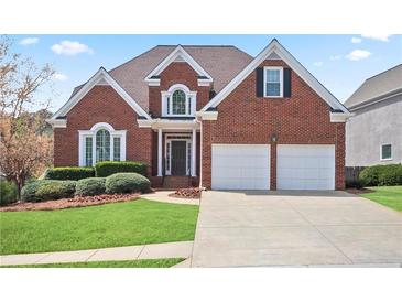 Charming red brick home with a well-maintained lawn, landscaping, and a two-car garage at 4093 Tritt Homestead Dr, Marietta, GA 30062