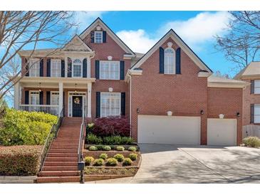 Beautiful two-story red brick home with a well-manicured lawn, two-car garage, and inviting entrance at 3509 Ivy Manor Se Rd, Smyrna, GA 30080
