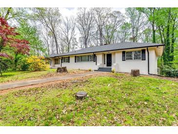 Charming single-story home with painted brick, black accents, and a well-manicured lawn at 1714 Highland Pl, Decatur, GA 30035