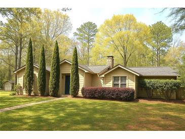 Charming single-story home featuring a lush green lawn and mature landscaping at 2701 East Mill Sw Way, Conyers, GA 30094