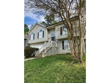 Charming two-story home with a well-maintained lawn and inviting front entrance with white stairs at 2250 Camp Town Way, Lawrenceville, GA 30044