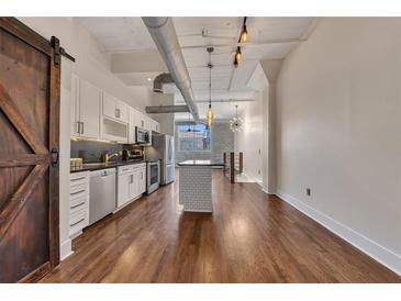 Spacious living room featuring hardwood floors, modern lighting, and a chef-inspired kitchen at 172 Haynes Sw St # 108, Atlanta, GA 30313