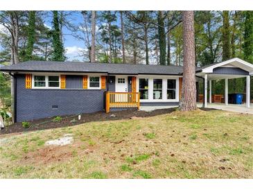 Charming home featuring a brick facade, orange shutters and a convenient carport at 2318 Plantation Dr, Atlanta, GA 30344