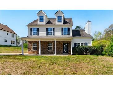 Charming two-story home featuring a stone facade, covered porch, and well-manicured lawn at 3267 Forrest Bluff Way, Lithonia, GA 30038