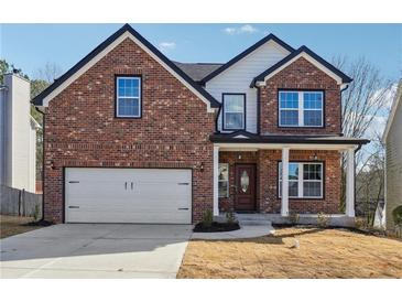 Charming brick home featuring an attached garage and a welcoming front porch at 7902 West Shore Cir, Riverdale, GA 30296