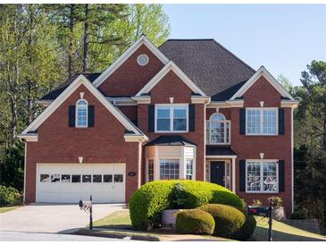 Traditional brick home featuring manicured lawn, two-car garage and classic architectural details at 2875 Factor Walk Blvd, Suwanee, GA 30024