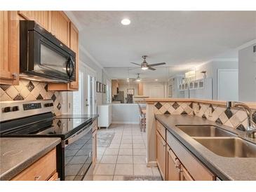 Bright kitchen featuring tile backsplash, stainless steel appliances, and ample counter space at 8 Arpege Nw Way, Atlanta, GA 30327