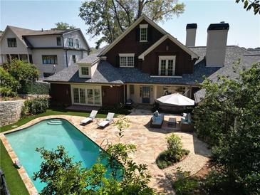 Stunning backyard with in-ground pool, stone patio, lounge chairs, and outdoor seating area at 219 Little John Ne Trl, Atlanta, GA 30309