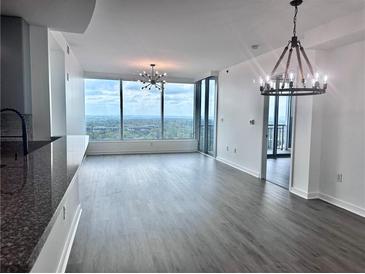 Bright living room featuring floor-to-ceiling windows with a stunning city view and modern light fixtures at 3338 Peachtree Ne Rd # 2701, Atlanta, GA 30326