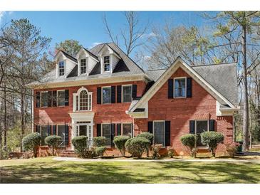 Beautiful brick two-story home featuring dormer windows and a well-manicured lawn at 3395 Hunters Place, Stonecrest, GA 30038