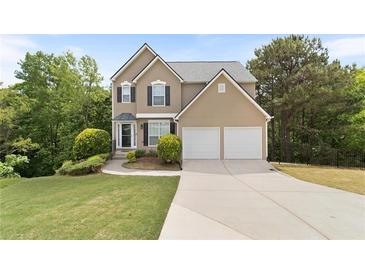 Charming two-story home boasts a two-car garage, manicured lawn, and inviting curb appeal at 7040 Magnolia Park Ln, Norcross, GA 30093