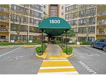 Exterior view of the apartment building entrance with covered awning and well-maintained landscaping at 1800 Clairmont Lk # A427, Decatur, GA 30033