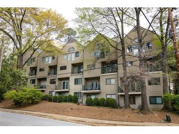 Multi-story condo building with balconies, surrounded by mature trees and landscaping at 67 25Th Nw St # 5, Atlanta, GA 30309