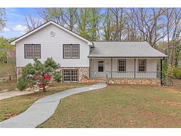 Charming split level home featuring stone accents, covered entry porch, and well-maintained front yard at 1143 Cedar Log, Austell, GA 30168