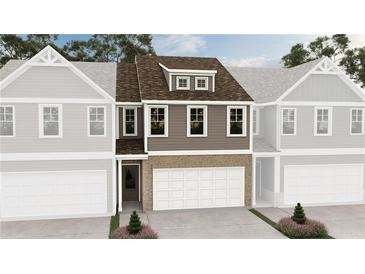 Charming townhome featuring a brick facade, attached garage, and neutral color palette at 6349 Towhee Way, Morrow, GA 30260