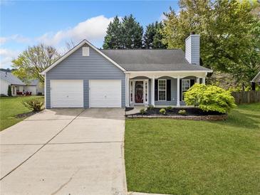 Charming single-Gathering home featuring a well-manicured lawn, two-car garage, and a welcoming front porch at 3227 Grove Trl, Acworth, GA 30101
