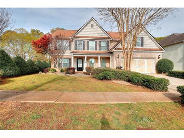 Charming two-story home featuring a well-manicured lawn and a classic brick facade with a two-car garage at 3320 Gardenside Dr, Loganville, GA 30052