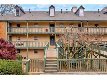 Three-story condo with wooden staircase, painted railings, and well-maintained landscaping at 113 Brittany Ct, Duluth, GA 30096