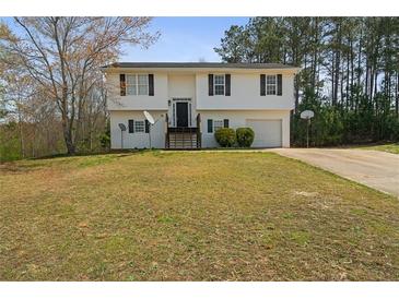 Split-level home showcasing a classic white facade, dark shutters, and well-maintained front lawn at 209 Emma Gilley Dr, Carrollton, GA 30116