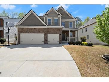 Beautiful two-story home with a stone and gray exterior, two-car garage, and well-manicured lawn at 5925 Pine Bluff Dr, Cumming, GA 30040