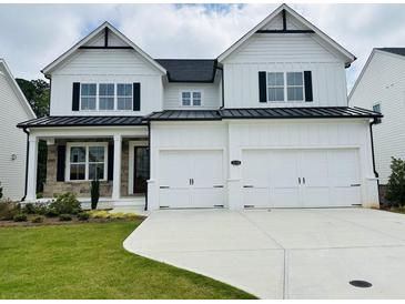 Striking two-story modern farmhouse with a white exterior, black accents, and a spacious two-car garage at 3330 Hillshire Dr, Cumming, GA 30028