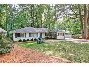 Charming ranch-style home with a lush green lawn, mature trees, and inviting curb appeal at 1309 Brookshire Ne Ln, Brookhaven, GA 30319