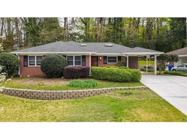 Charming brick home with a well-maintained lawn and beautiful landscaping, perfect for curb appeal at 1323 Christmas Ne Ln, Atlanta, GA 30329