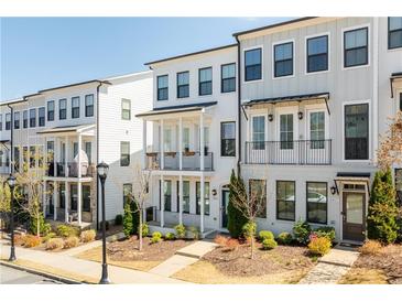 Charming townhome featuring a classic exterior design with inviting balconies and manicured landscaping at 2013 Rockledge Ne Rd, Atlanta, GA 30324