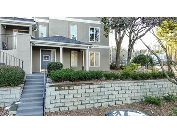 Attractive exterior with a gray stucco facade and well-maintained landscaping and retaining wall at 64 Saint Claire Ne Ln, Atlanta, GA 30324