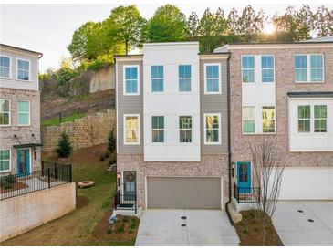 Charming three-story townhome with brick and siding exterior, featuring an attached two-car garage at 399 Se Skylar Way, Atlanta, GA 30315