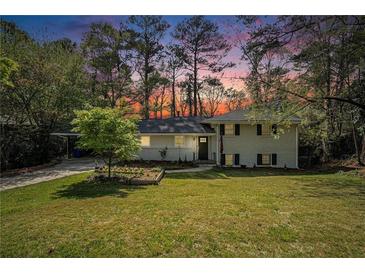 Charming two-story home with a brick facade, landscaped front yard, and driveway with carport at 539 Collingwood Dr, Decatur, GA 30032