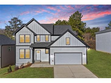 Charming two-story home featuring gray siding, black trim, and a well-manicured lawn at sunset at 3205 Tackett Rd, Douglasville, GA 30135
