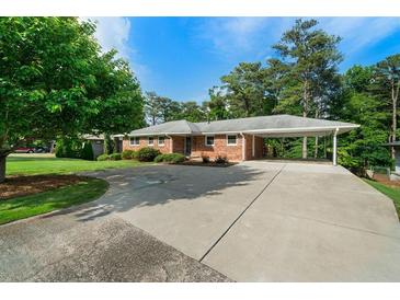 Charming brick home with a covered parking area and a spacious, paved driveway at 3925 Orchard Se Rd, Smyrna, GA 30080