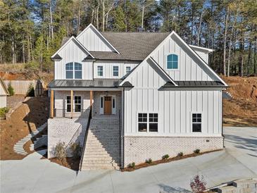 Stunning two-story home with white vertical siding, brick base, and inviting staircase at 52 Lake Overlook Dr, White, GA 30184