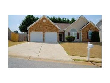 Charming single-Gathering home features a two-car garage, stone accents, and a well-manicured lawn at 681 Nine Oaks Cir, Villa Rica, GA 30180