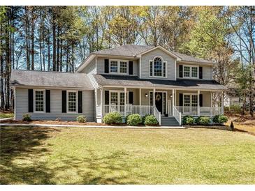 Traditional two-story home featuring a welcoming front porch and black shutters, surrounded by a well-manicured lawn at 3227 Heritage Way, Buford, GA 30519