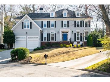 Stately two-story home with a manicured lawn, attached garage, and a welcoming blue front door at 710 Greystone Ne Park, Atlanta, GA 30306