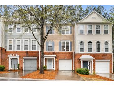 Charming townhome featuring a brick facade, attached garage, and well-maintained landscaping at 3987 Howell Park Rd, Duluth, GA 30096
