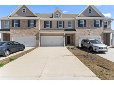 Inviting townhome with a brick facade, attached garages, and a long driveway for ample parking at 2990 Fareed St, Douglasville, GA 30135