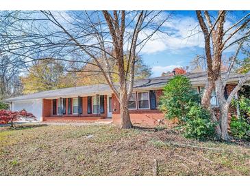 Charming single-story brick home featuring a well-maintained front yard and attached garage at 831 Sinyard Rd, Lithia Springs, GA 30122