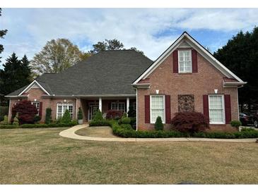 Charming single-story brick home with manicured lawn and mature landscaping offering classic curb appeal at 84 Nw Gloster Nw Rd, Lawrenceville, GA 30044