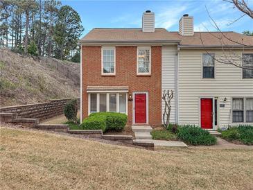 Charming two-story brick townhome with a red door and well-maintained landscaping at 193 High Creek Dr, Roswell, GA 30076