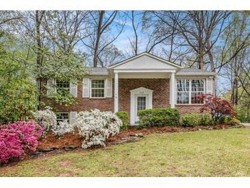 Charming brick home featuring a well-manicured front yard with colorful flower beds and lush landscaping at 2183 Seaman Cir, Atlanta, GA 30341